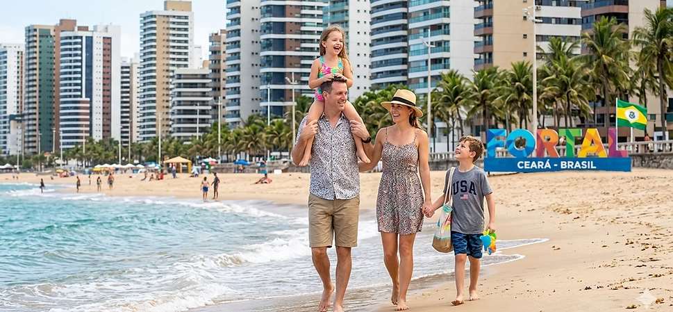 A family walking on a beach in Fortaleza, Ceará, Brazil